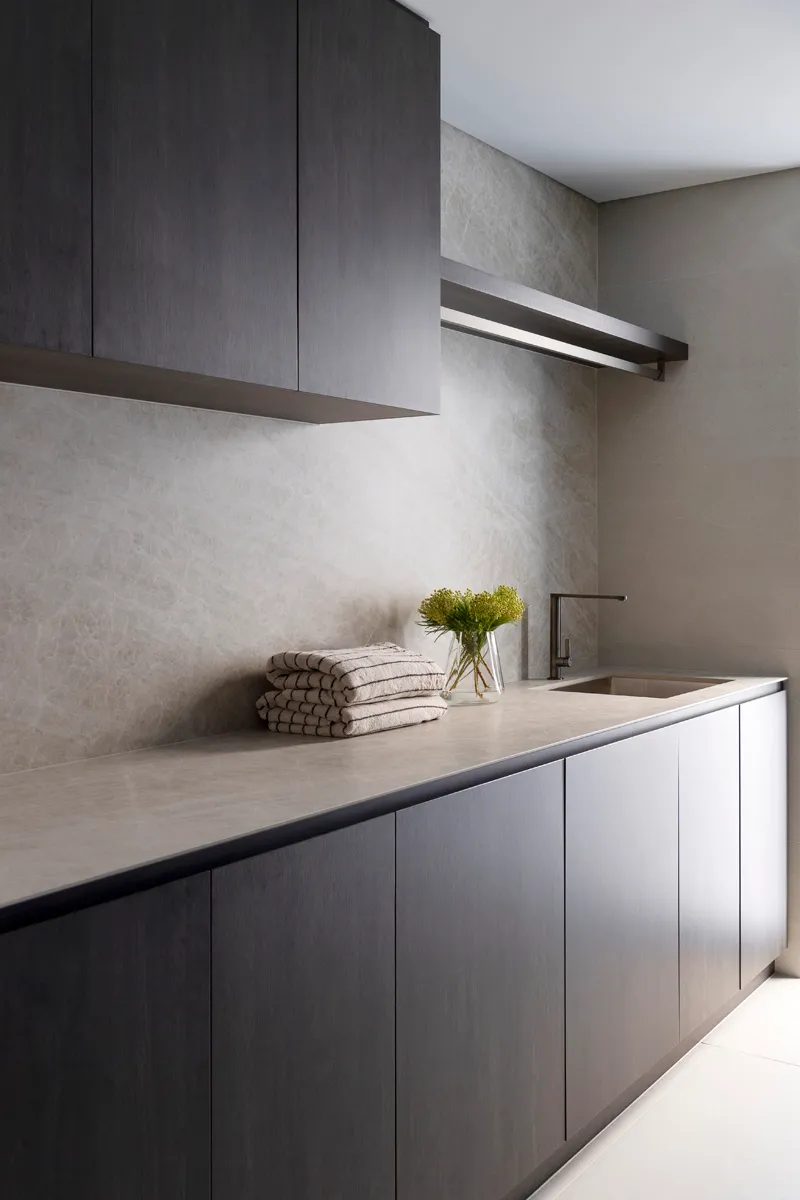 Laundry design with custom cabinetry and stone benchtop by Collected Interiors Perth