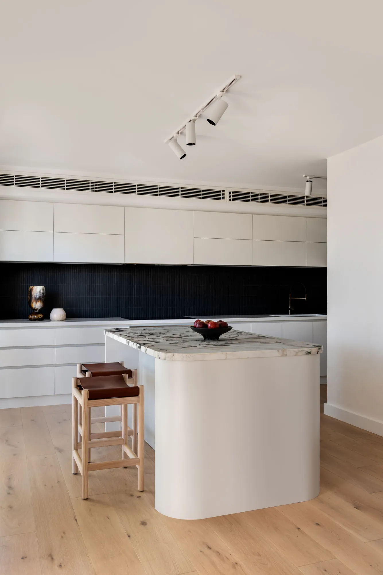 A renovated kitchen in a 1980s Claremont home, with natural stone benchtop and custom cabinetry by Collected Interiors